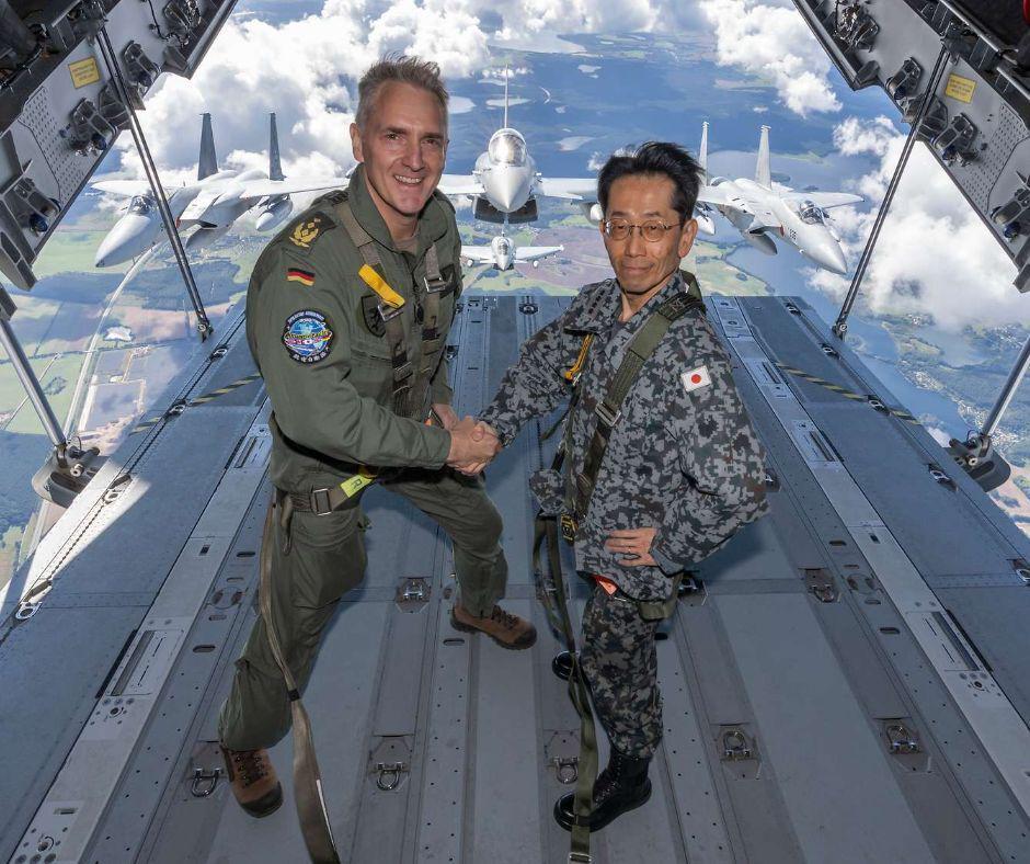 Luftwaffe Neumannと日本空軍司令官のMoritaは、ヨーロッパ製のエアバスA400m航空機のオープンテールランプを握手します。それらの背後：2人の日本のF-15Jイーグルと2人のLuftwaffeユーロ拡張者。 EUと日本は昨年防衛協定に署名しました