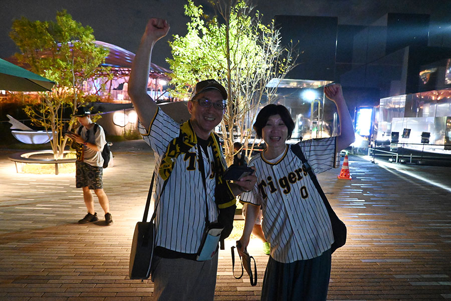 大阪在住、阪神ファンのご夫婦。「今日の試合のチケットが取れなかったので、どこか記念になる場所で見届けたいと思って」と万博を訪れた（9月7日・いのちのパーク付近）