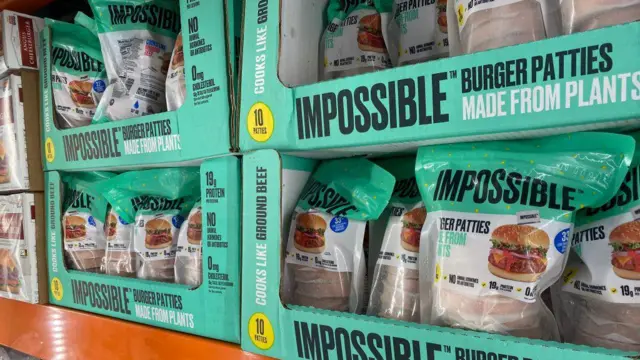 スーパーマーケットの棚に並ぶ、鮮やかな緑色の「インポッシブル」バーガー・パテ4箱。箱には「植物から作られている」とも書かれている