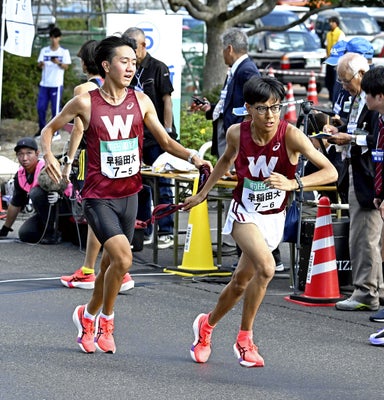 第５中継所でたすきをつなぐ早大５区の堀野正太（左）と６区の工藤慎作（島根県出雲市で）＝大石健登撮影