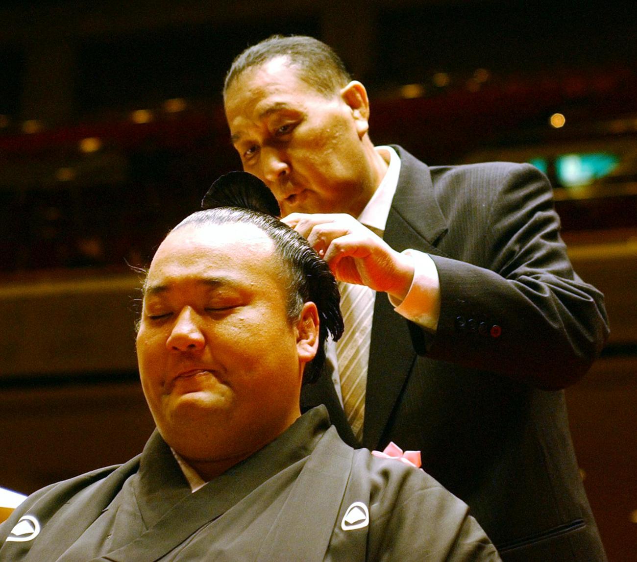 断髪式に臨んだ貴ノ浪は、涙をこらえながら二子山親方（元大関貴ノ花）にはさみを入れられる（2005年1月30日撮影）