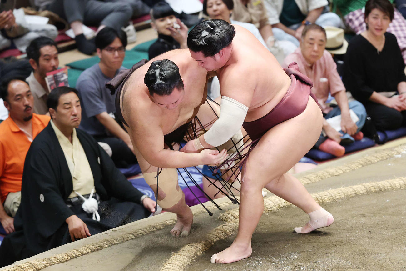 秋場所13日目、上手投げで朝乃山（左）を破る錦富士（撮影・宮地輝）