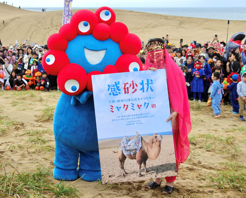 ミャクミャク 鳥取県副知事から感砂状！“アフター万博”『鳥取砂丘ハロウィンパーティー after EXPO2025』開催
