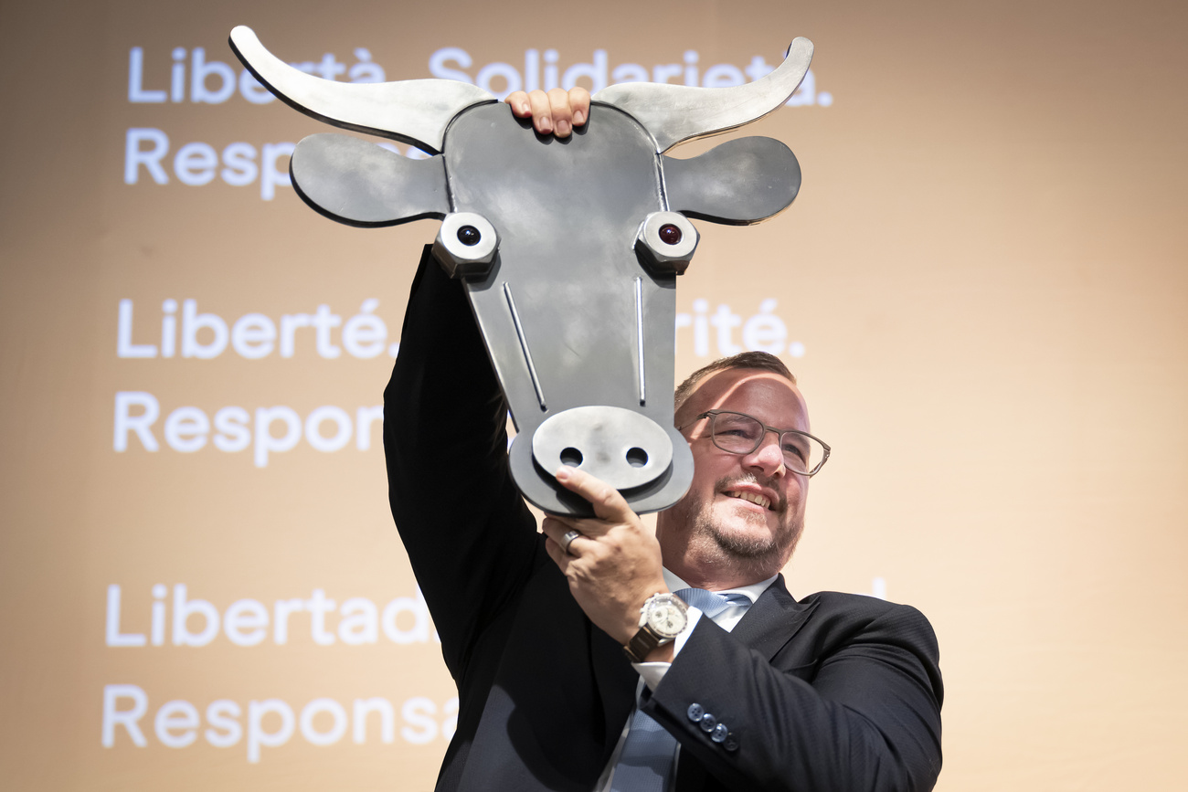 牛のお面を掲げる男性