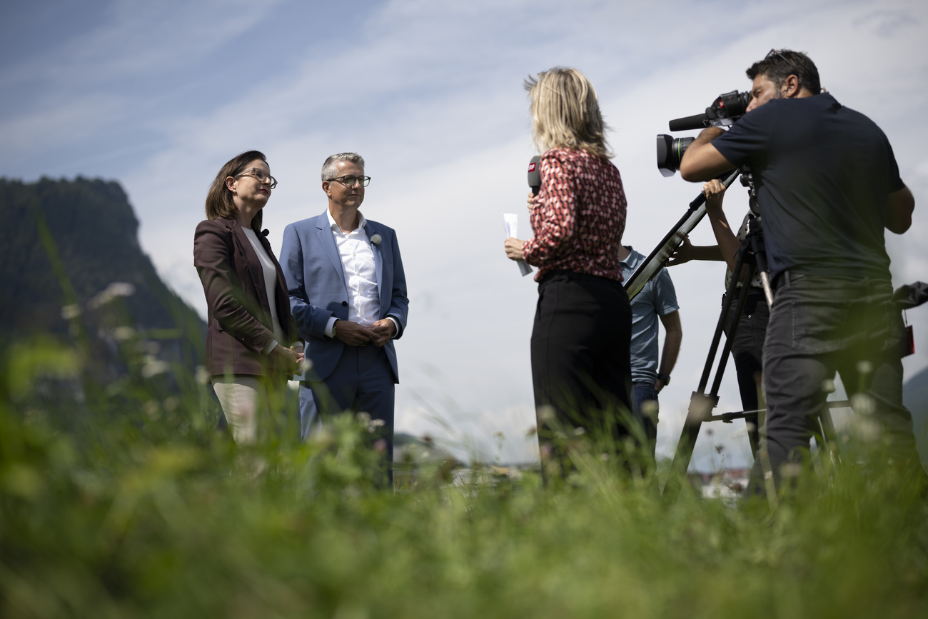 屋外でインタビューを受ける男女