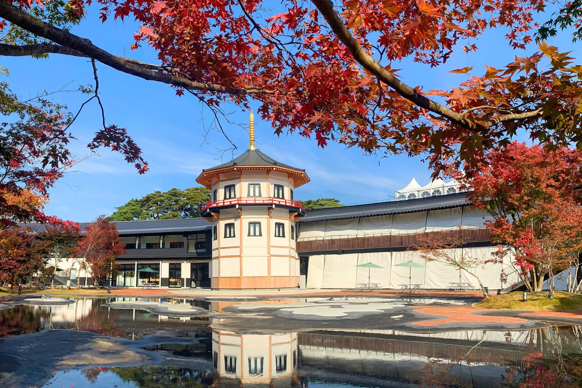 紅葉と寺院の美しい風景写真。水面に映る建物と紅葉が印象的。