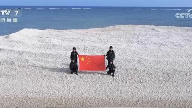 南沙諸島のサンド礁で中国国旗を掲げる中国海警局の4人