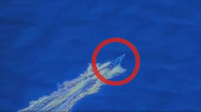 海上を小型ボートが波を立てて航行している画像。ボートの部分に、赤い丸で印がついている