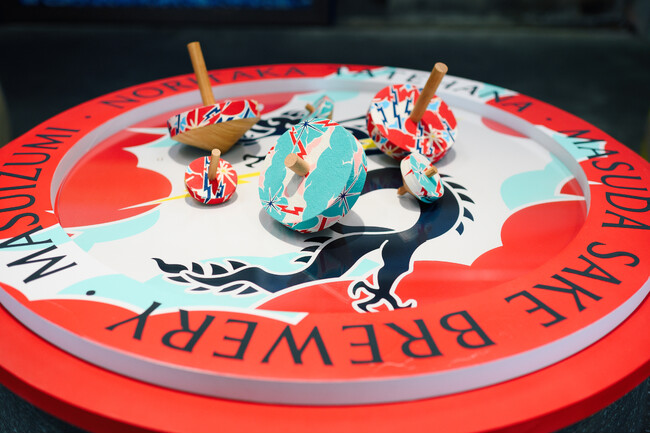 舘鼻則孝による富山県・越中八尾の伝統工芸「型染め和紙」を活かした作品が「GO FOR KOGEI 2025」で公開。会場となる桝田酒造店は、銘酒「満寿泉」で知られる明治26年創業の歴史ある酒蔵。｜北日本新聞webunプラス