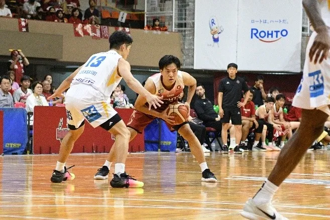 バスケットボールの試合の様子。ボールを持つ選手が相手選手と対峙している。