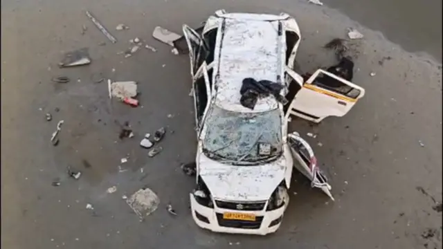 河床に落下した自動車。白いワゴン車で、窓や扉などが破損している