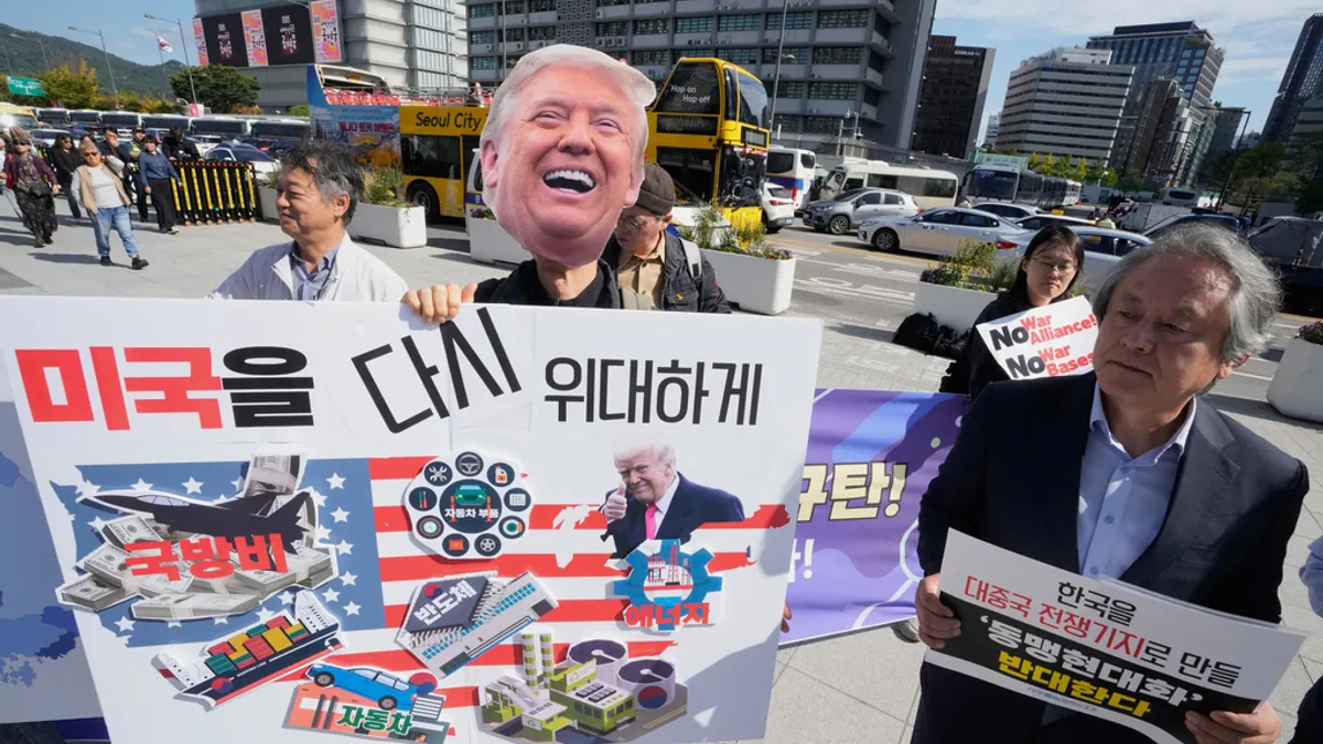 韓国の反トランプデモ参加者が風刺ポスターを持って通りに出る。（AP通信）