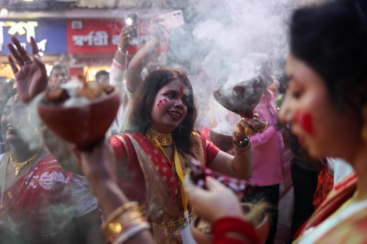 女神ドゥルガーの像の前で伝統的な踊りを披露する信者＝３日、インド・コルカタ/Sahiba Chawdhary/Reuters