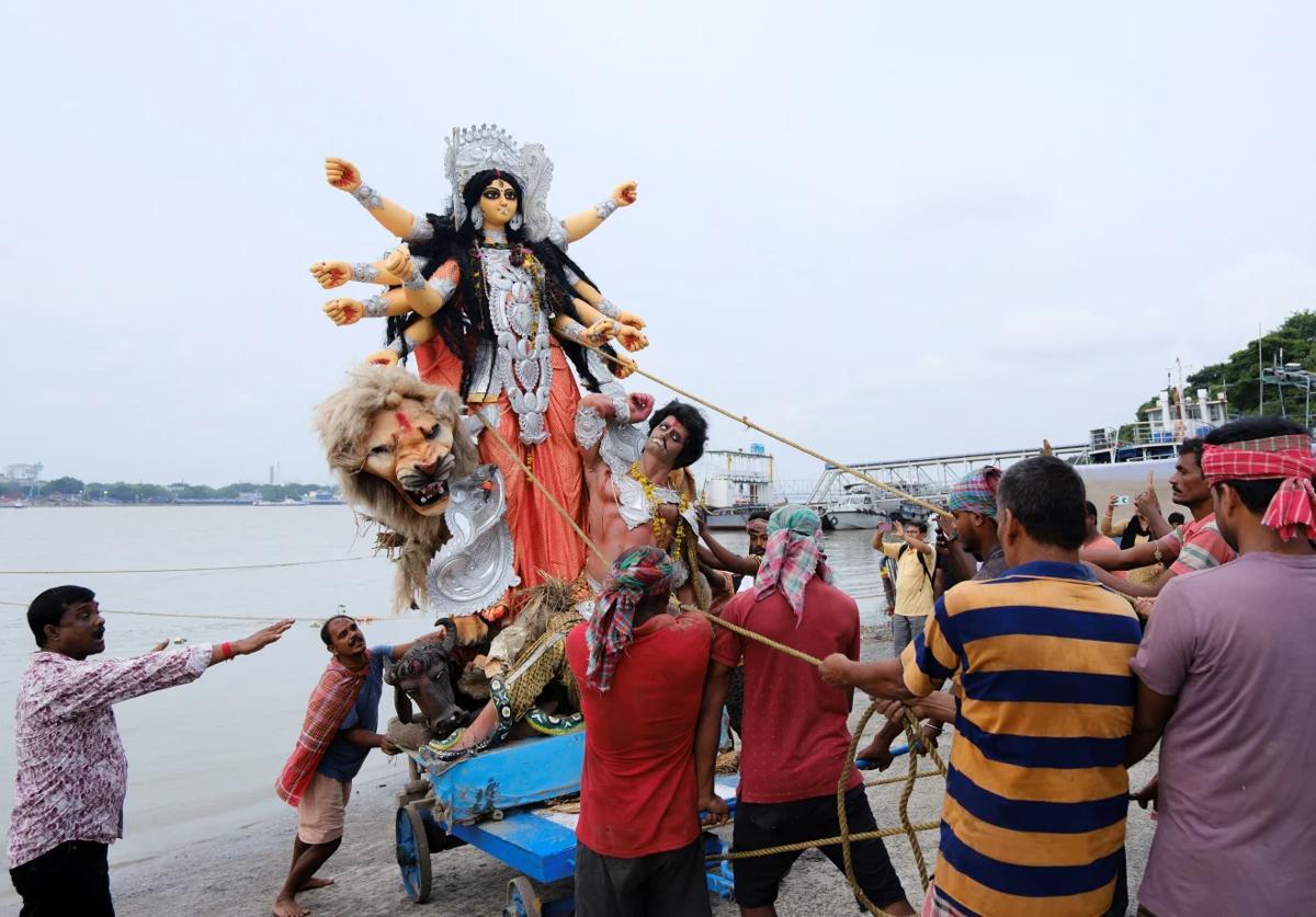 ヒンドゥー教の女神ドゥルガーの像がガンジス川に沈められて、祭りが終わりを迎える＝４日/Sahiba Chawdhary/Reuters