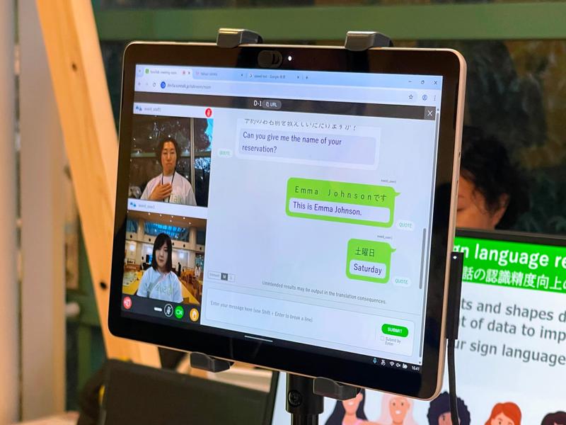 国際手話のユーザーと日本手話のユーザーがSureTalkを通じて会話している様子。外国の手話は「国際手話」と「アメリカ手話」に対応し、画面に表示されるテキストは11カ国語の中から選ぶことができる。手話→テキスト化→手話→テキスト化の流れがスムーズでテンポよく会話が展開されているのが印象的だった。 