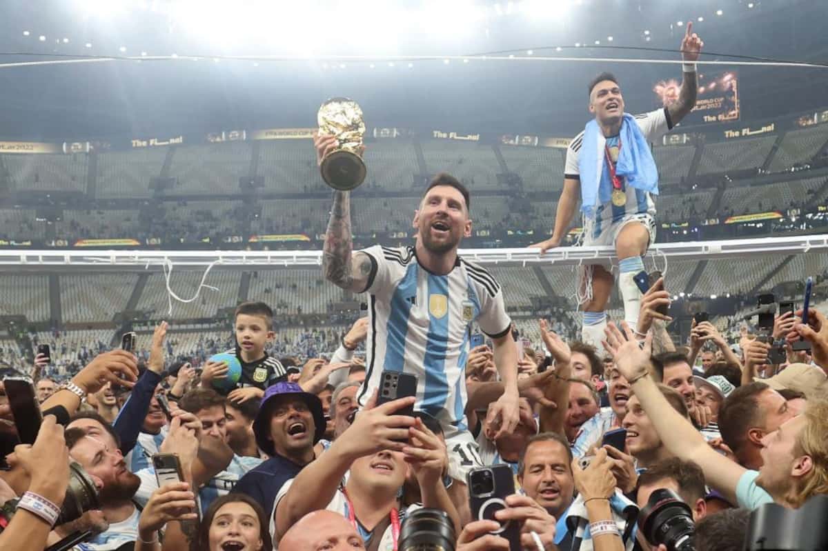 2022年W杯カタール大会でアルゼンチンを3度目の優勝に導き、トロフィーを掲げるメッシ（中央）