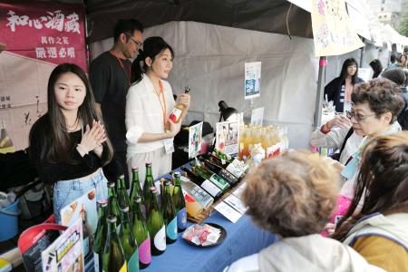 　秋田県が台北で開催した観光物産展で日本酒を売り込む関係者＝２２日（共同）