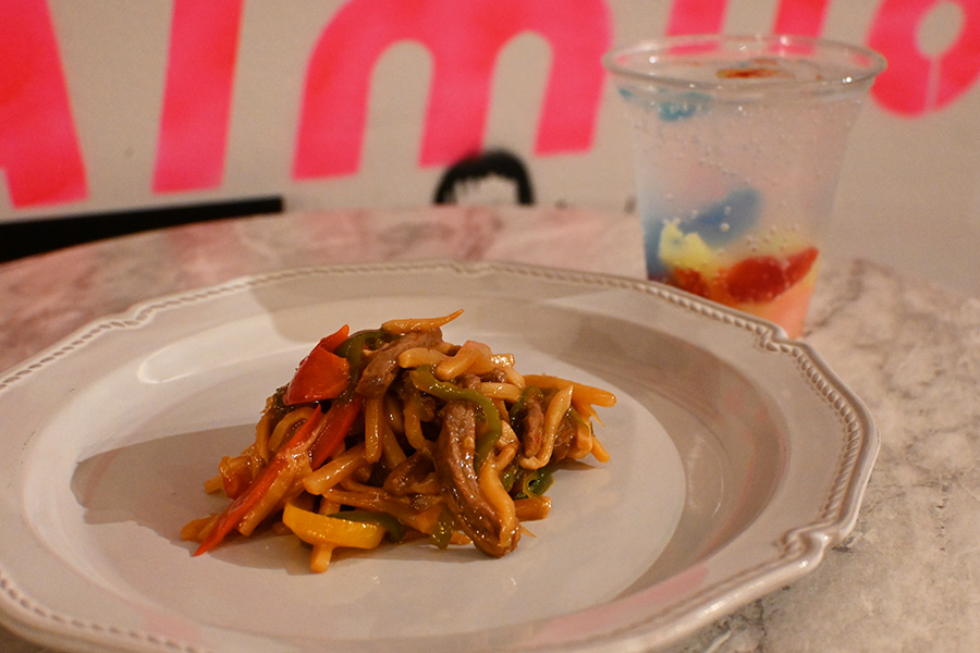 左から、作品『ウィーアーリトルゾンビーズ』とコラボしたカナシミ チンジャオロース（1210円）、ウィーアーリトルゾンビーズカラーソーダ（1100円）。コラボ商品は上映期間中のみ販売