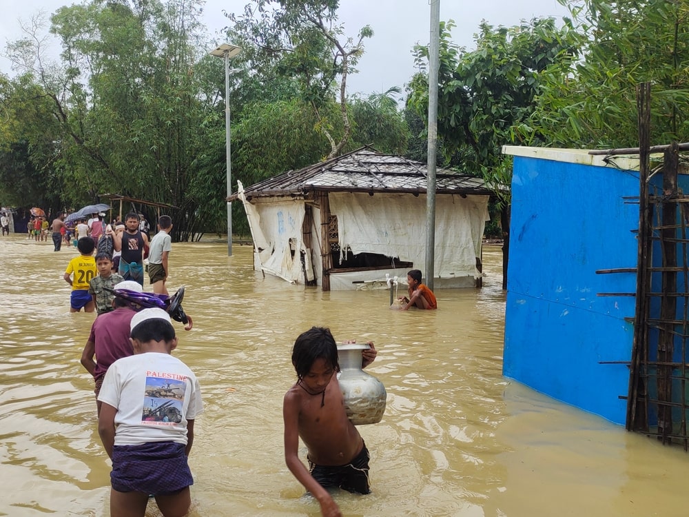 水害で水につかりながら移動する人々
