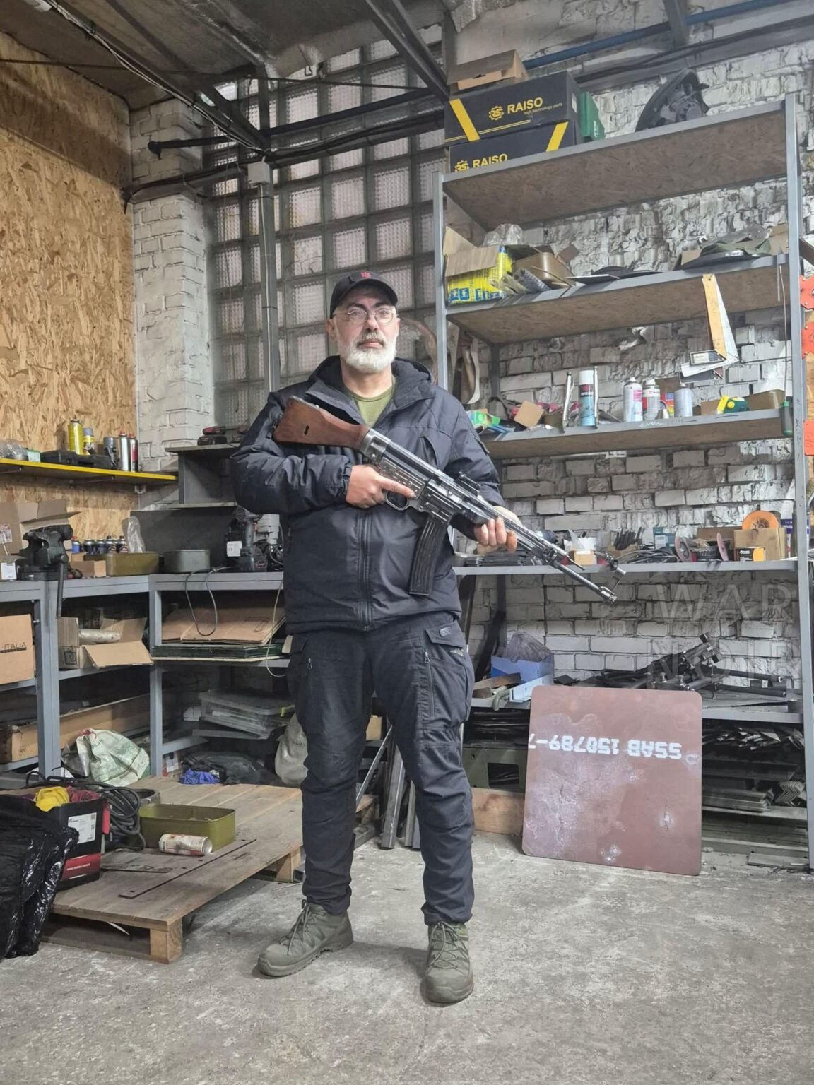ウクライナ軍の退役軍人が、(7.92x33mm) クルツ銃に装填されたドイツ製 STG (MP-43 または 44) アサルトライフルを持って作業場に立っています。