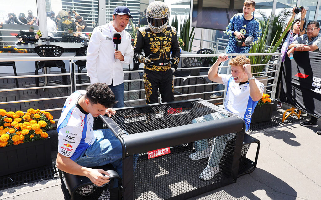 パドックでマリオ・アチとゲームを楽しむレーシング・ブルズのアイザック・ハジャーとリアム・ローソン、2025年10月23日(木) F1メキシコGPプレビュー（エルマノス・ロドリゲス・サーキット）