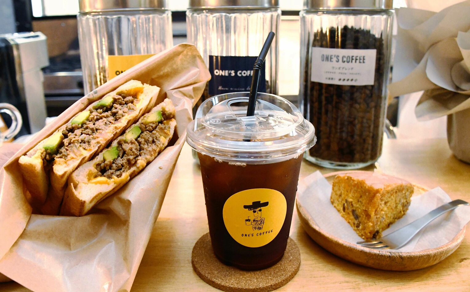 <div class="caption">ＯＮＥ’Ｓ　ＣＯＦＦＥＥお薦めの（左から）タコス風ホットサンド、ＯＮＥ’Ｓブレンド、キャロットケーキ。フードはコーヒーと一緒に楽しめる味に仕上がっている</div>