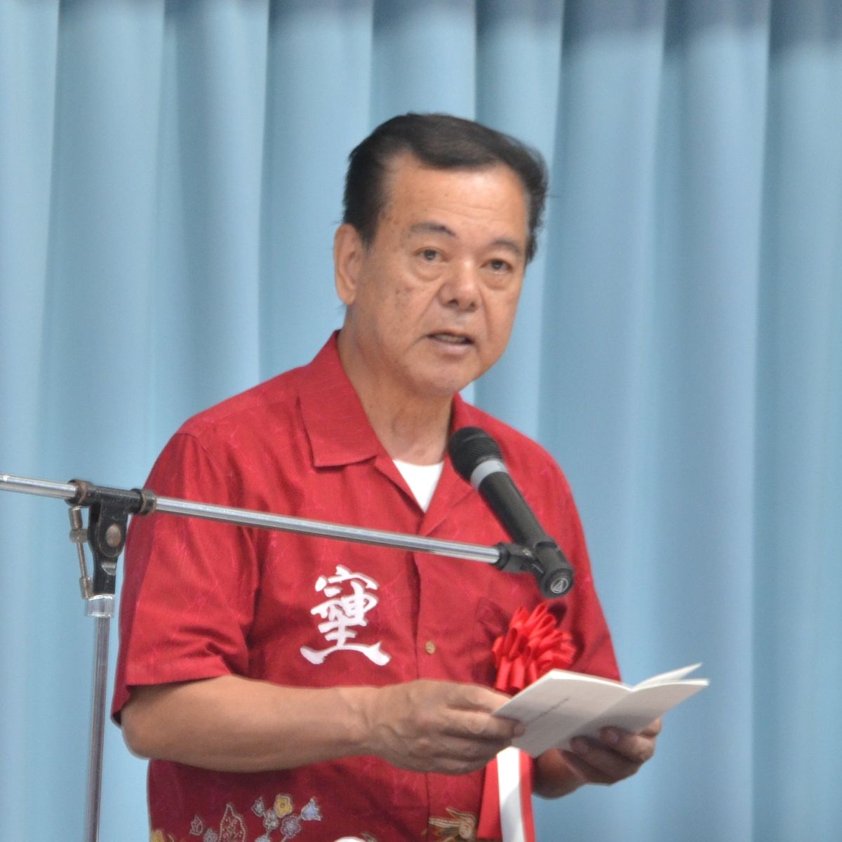 奥武島観音堂４１０年祭記念式典であいさつに立つ古謝景春南城市長＝９日午後５時半ごろ、南城市玉城奥武