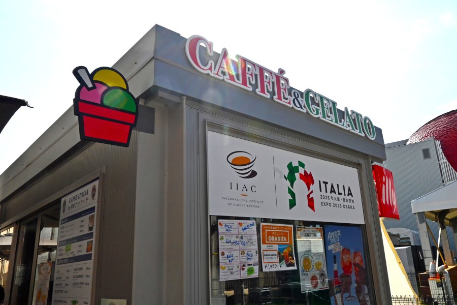 代表の桃井祐美子さん（左）。「カフェ＆ジェラートイタリア」の「イタリアちゃん」イラストの前でスタッフとともに（10月14日「大阪・関西万博」）