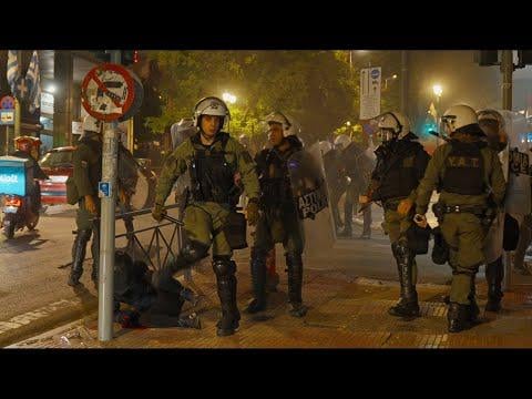 マタツィス、地面に倒れたヘルメットをかぶったデモ参加者の顔を蹴る