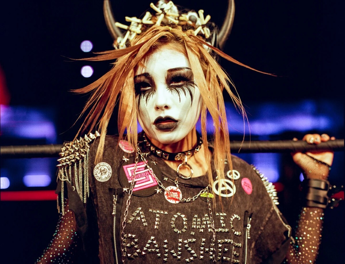 試合前にリングサイドでポーズを取るディフェンディングチャンピオンのアトミック・バンシー/Ysa Perez/Sukeban