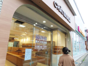 あさって（2025年）12月3日（水）に新規オープンする「シャトレーゼ妙蓮寺駅店」。11月27日（木）午前、店頭に“無人決済”店舗としてのオープン日を掲出すると驚きをもって表記に見入る人々の姿が見られていた。右側（妙蓮寺駅入口側）はドラッグストア「Fit Care DEPOT（フィットケアデポ）妙蓮寺店」