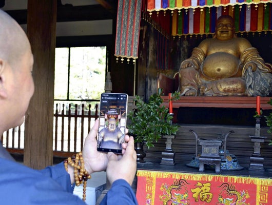 萬福寺が導入したガイドアプリ。画面の中で「布袋」が動く（京都府宇治市で）