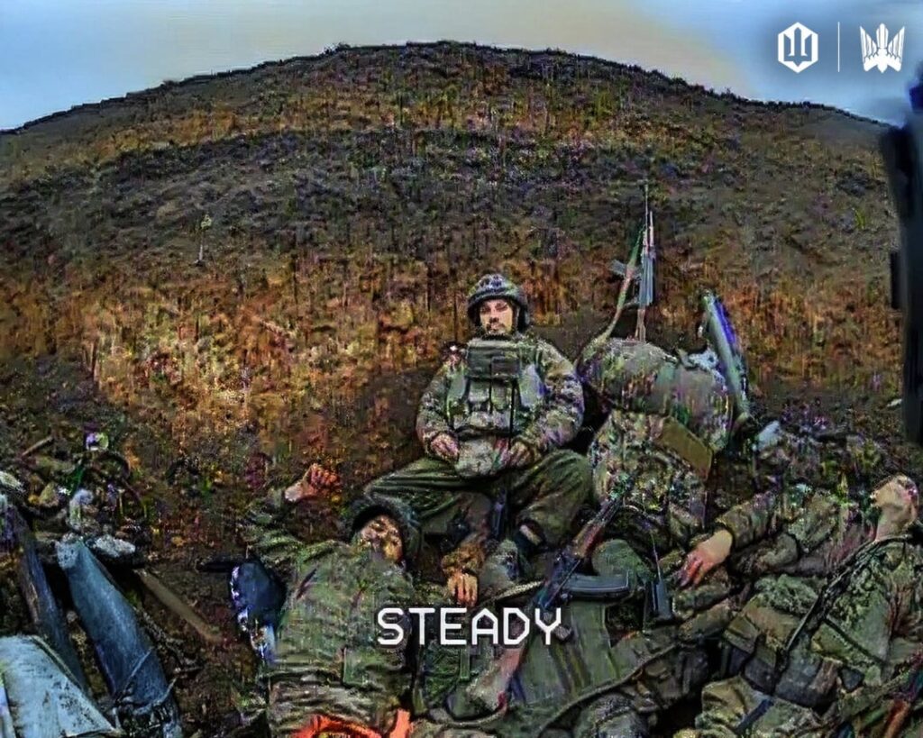 ドローンPOV: 最後に残ったロシア歩兵が、死んだ仲間の死体の山の上に座り、近づいてくるFPVを見つめている。