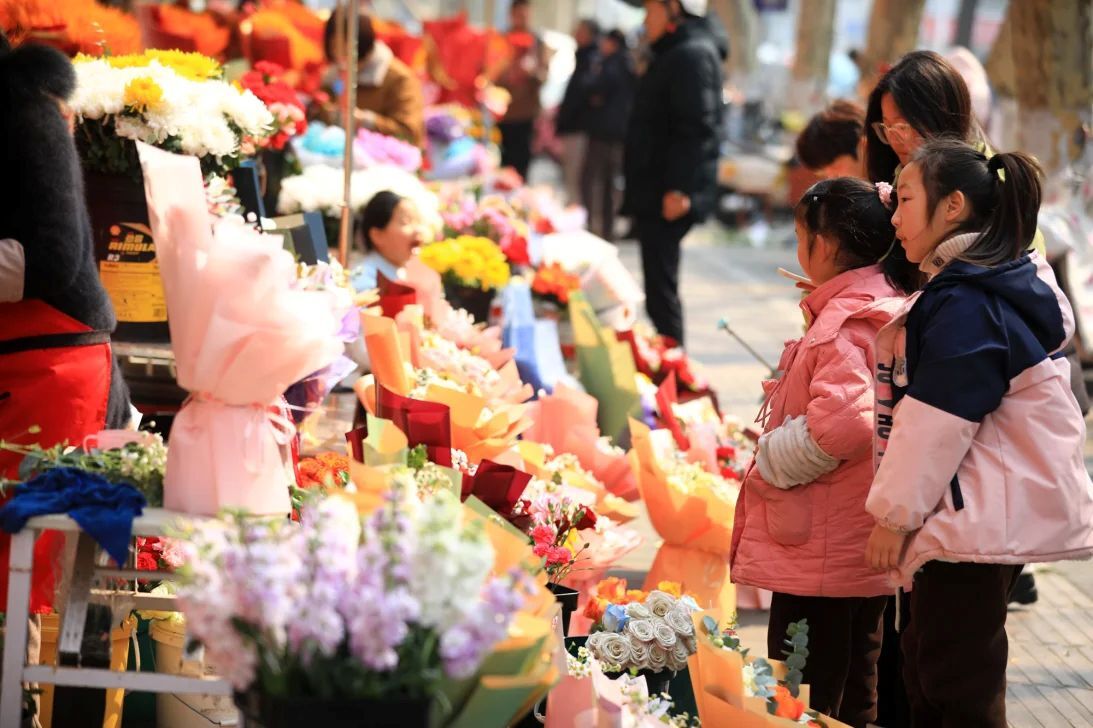 今年3月8日の国際女性デーを記念して、中国・淮安市の市場で花を買い求める人々/Zhou Changguo/Visual China Group/Getty Images