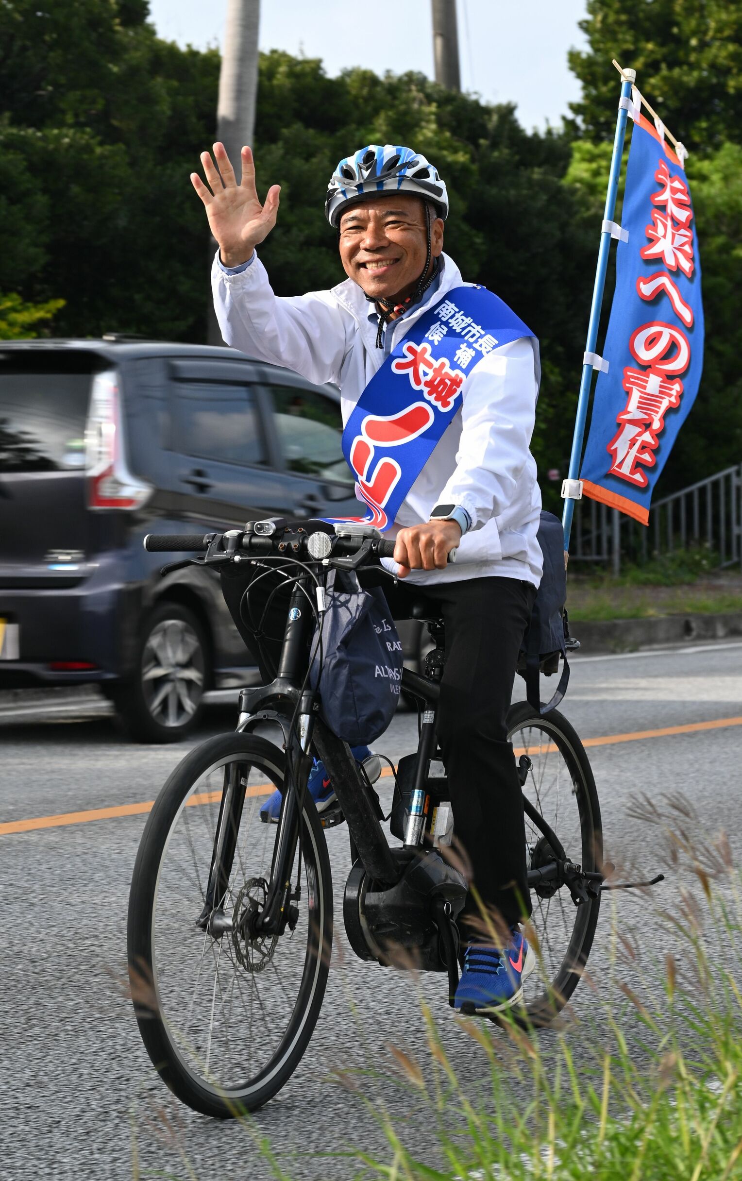 自転車で市内を回り支持を訴える大城憲幸さん=14日午後、南城市佐敷屋比久(宮城貴浩撮影)