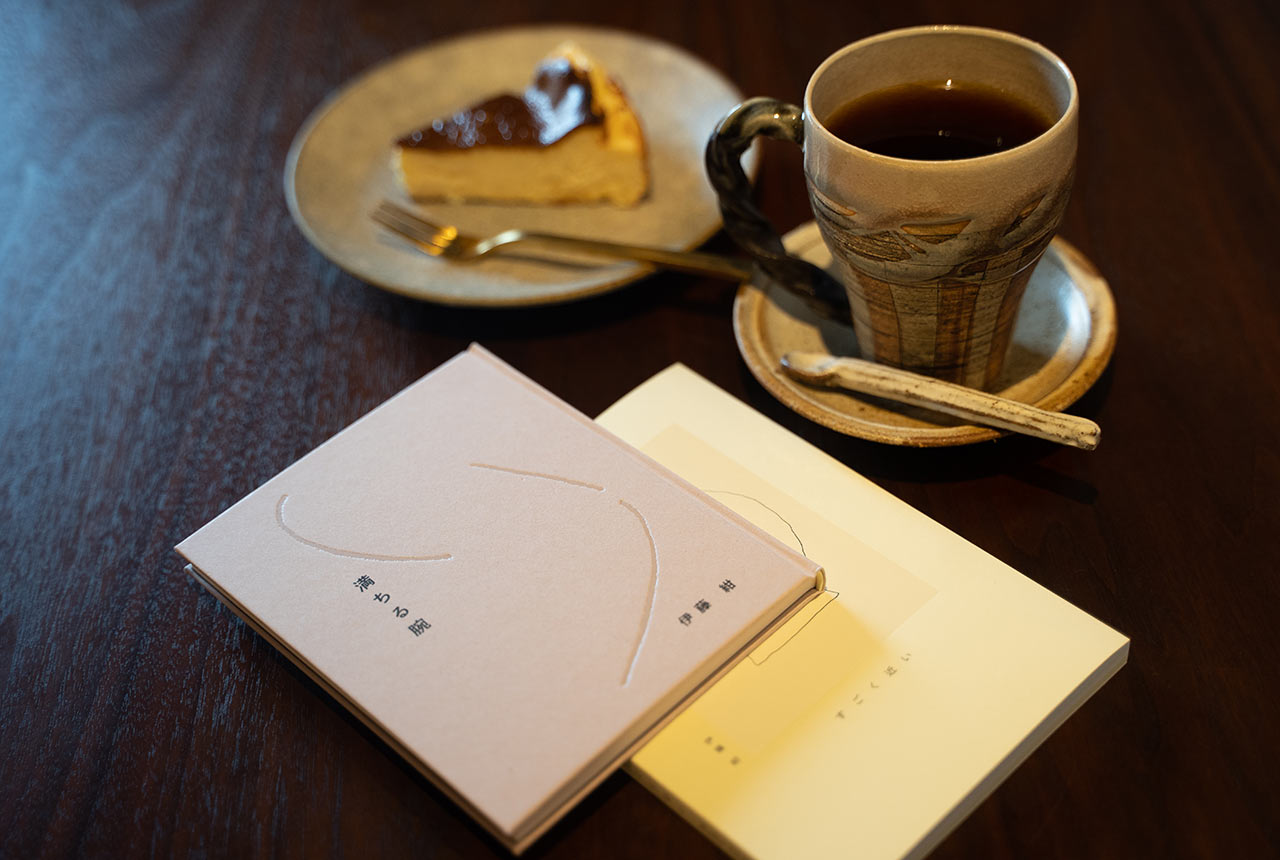 テーブルに置かれた２冊の本と、コーヒーとケーキ
