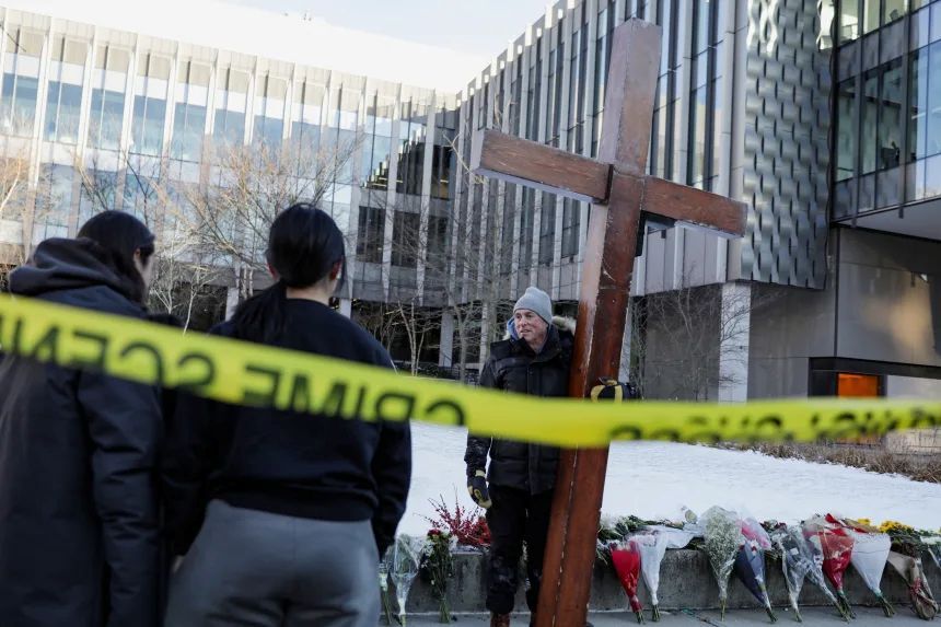 12月15日、銃撃事件の起きたブラウン大学の施設の前で十字架を抱え、学生らと言葉を交わすビーズリー氏/Taylor Coester/Reuters