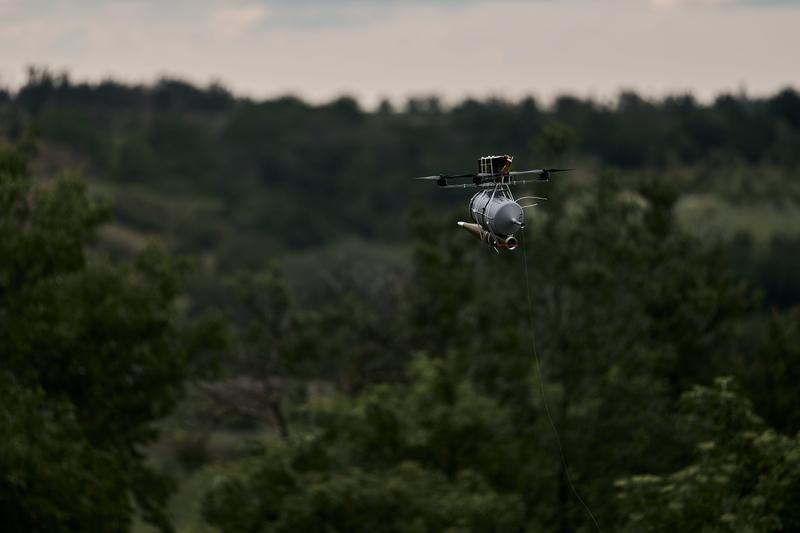 A drone armed with a warhead is flown as pilots of the 28th mechanised brigade of the Armed Forces of Ukraine test a fibre optic FPV drone with RPG munition.