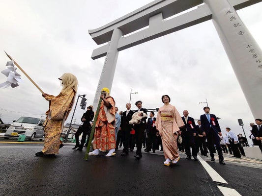 橋を渡り初めし、開通を祝う住民ら（島根県出雲市で）