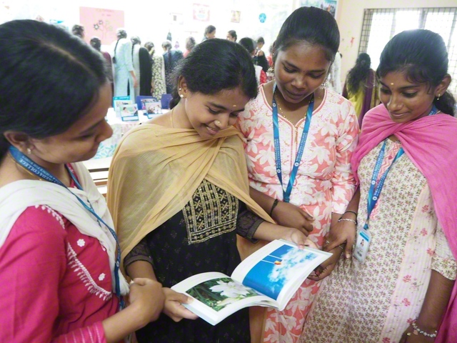 池田先生の写真を手に取りながら語らう学生たち