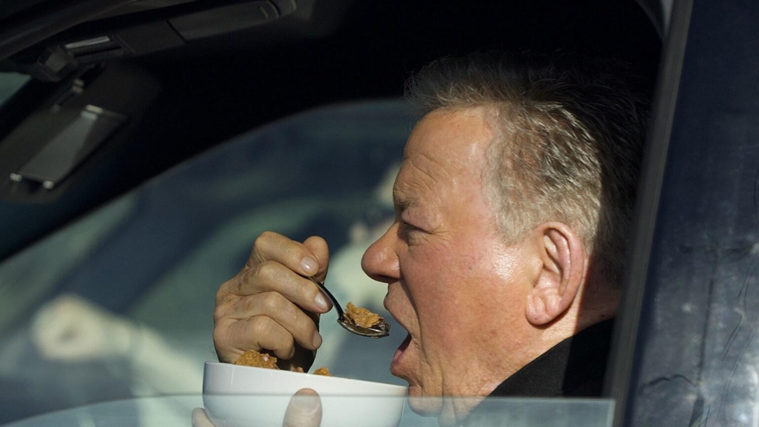 ウィリアム・シャトナー、車の中で信号待ちでボウル一杯のシリアルを食べているところを撮影