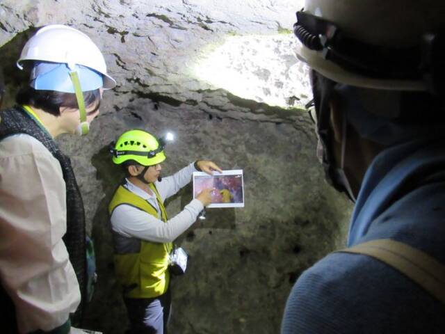 洞窟内の様子を説明する台湾の案内人とそれを聞く人