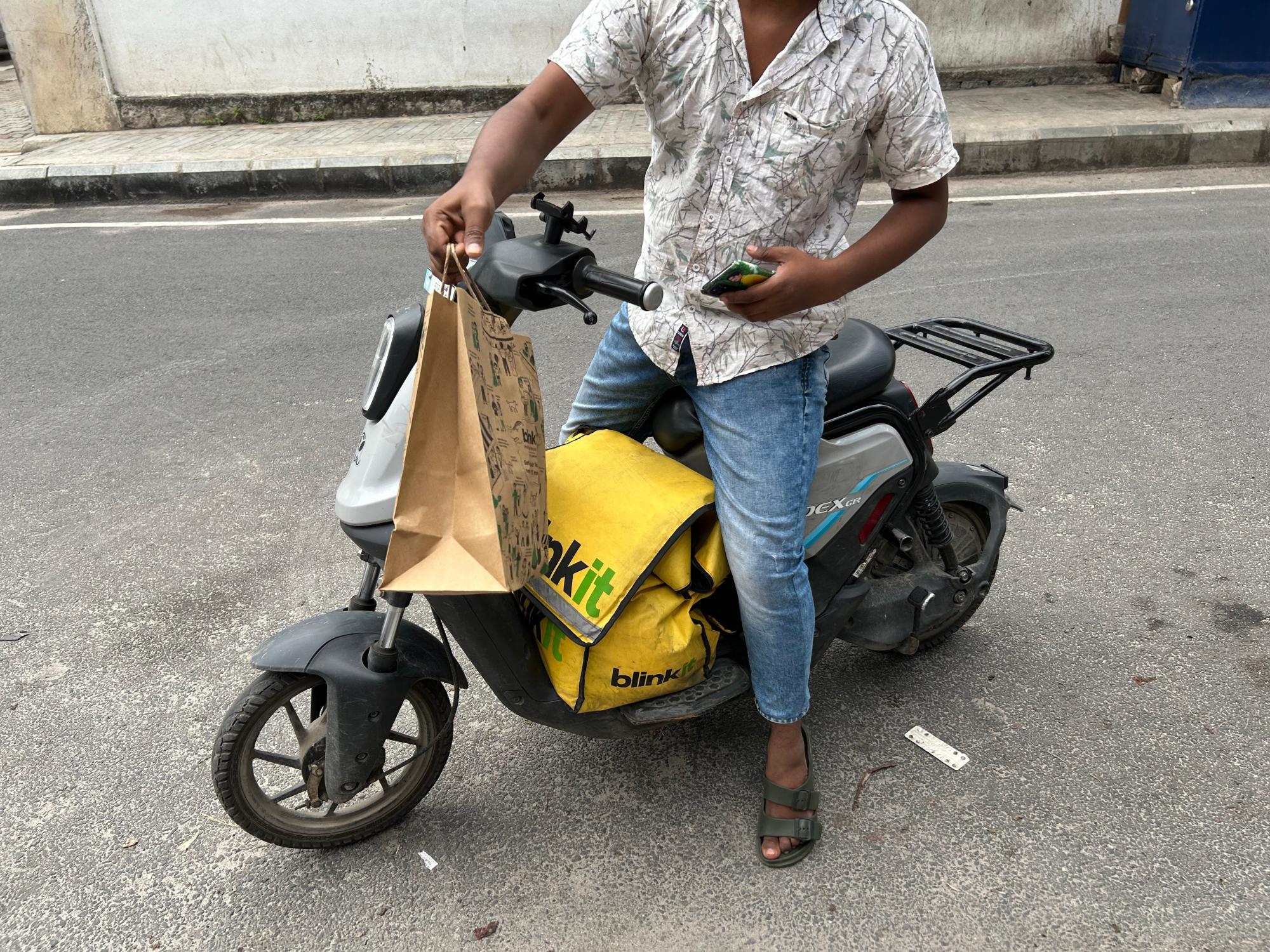 筆者に配送をしてくださったクイックコマースの配送員と受け取った荷物（筆者撮影）