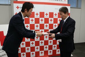 日本赤十字社県支部の西出事務局長（右）に寄付金の目録を手渡す日本生命滋賀支社の濱島支社長＝大津市京町４丁目・日本赤十字社県支部