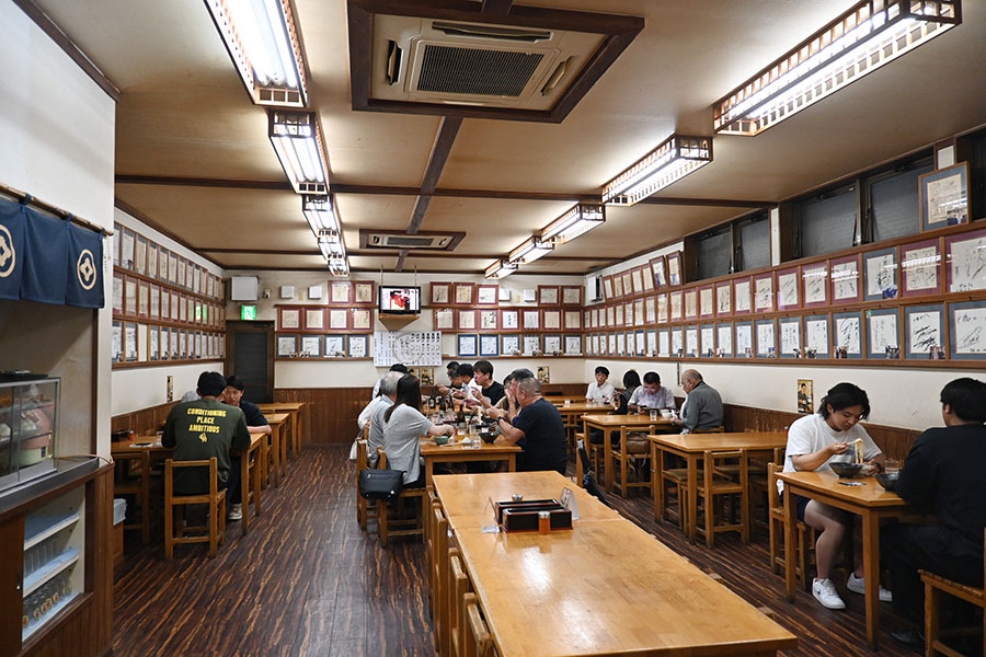 広々とした店内には著名人のサインがずらり。夜が深まるごとに客足が増えていく