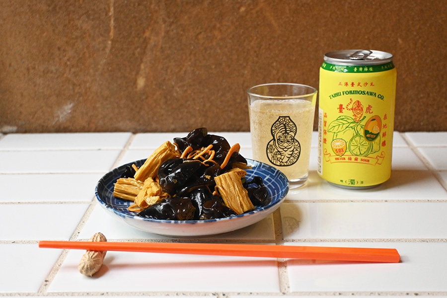 湯葉ときくらげ、漢方としても珍重されるサナギダケを青山椒入りのスープでゆでた「涼拌腐竹木耳」（湯葉ときくらげの和え物、650円）。台湾のブルワリー「タイフーブルーイング」のレモンフルーツエール（1100円）と一緒に