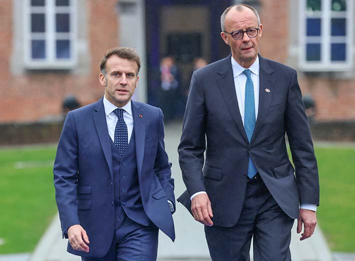 フランスのマクロン大統領（左）とドイツのメルツ首相＝12日、ベルギー中部リンブルフ州（ＡＦＰ時事）