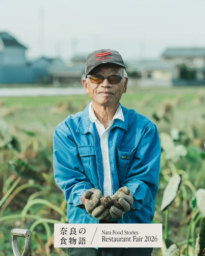 収穫した里芋を持つ生産者のポートレート