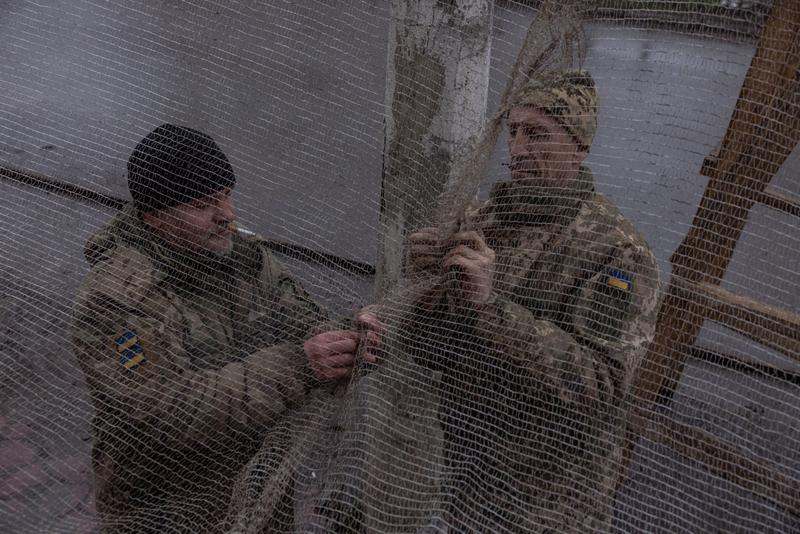 ウクライナ軍の兵士は、ロシアのドローンから防御するために陣地や兵器を低コストのネットで覆っている。