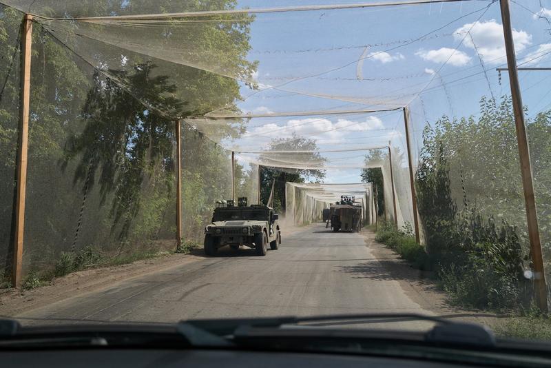 ウクライナはロシアのドローンから車両を守るため、道路の上をネットで覆っている。